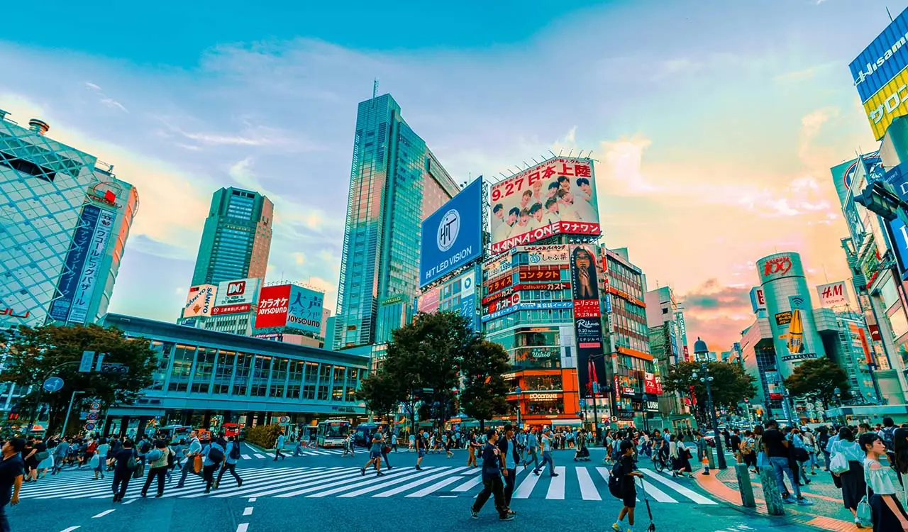 a city street with many buildings and people walking