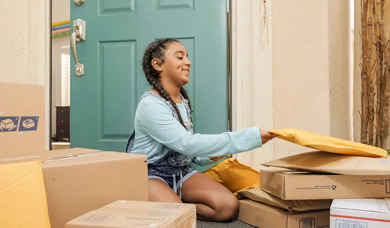 young girl with pile of amazon packages