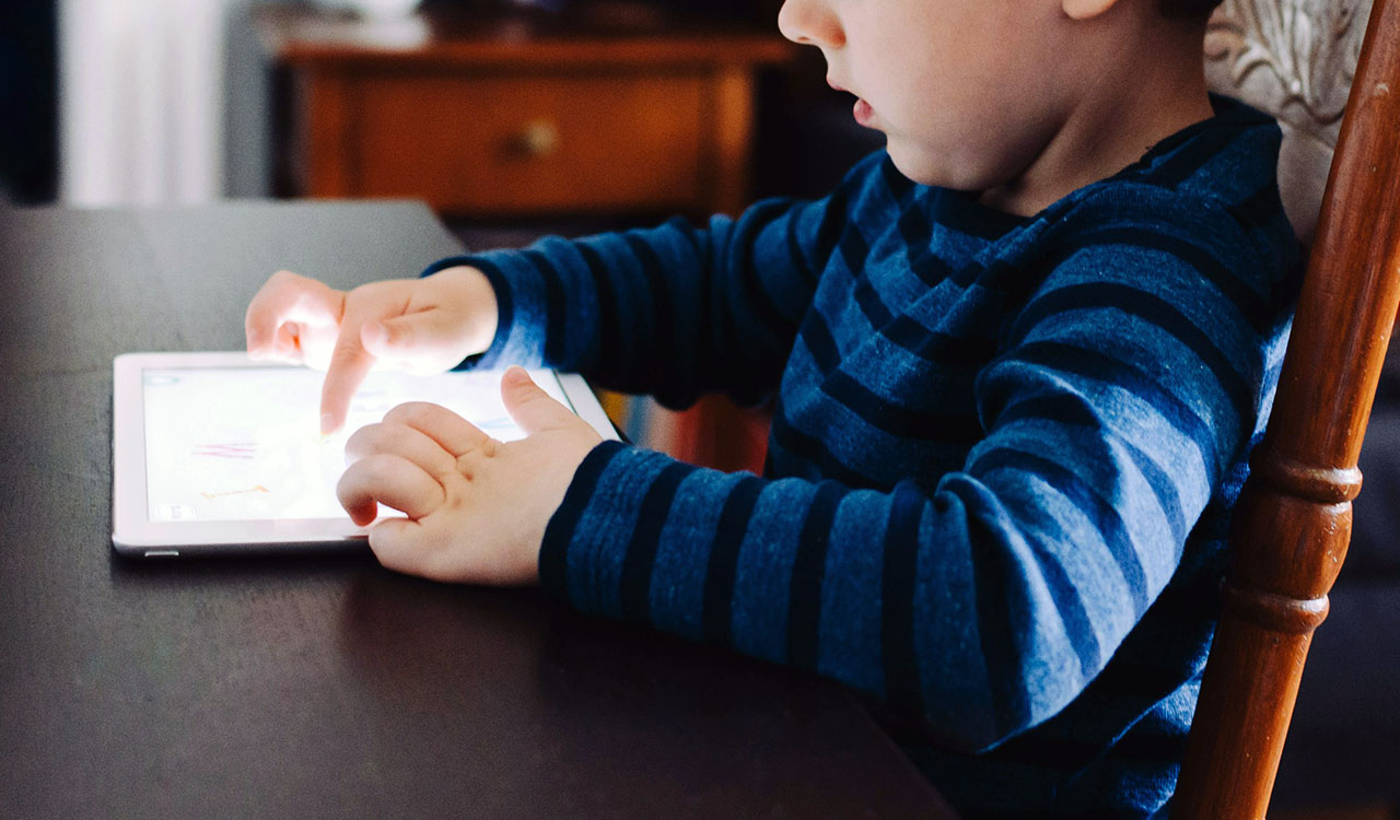 kid playing on tablet