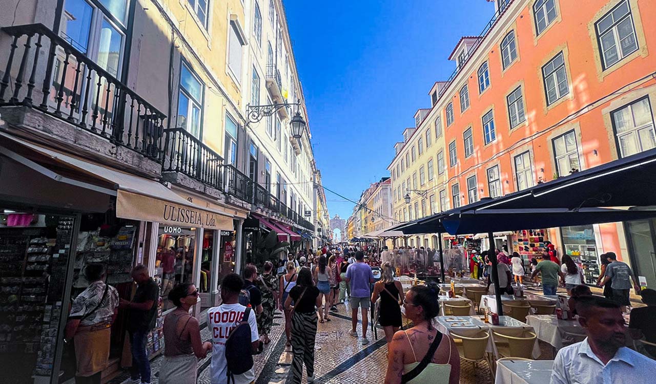 people walking on busy street under blue sky